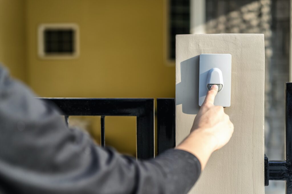 Man's hand pressing a doorbell button
